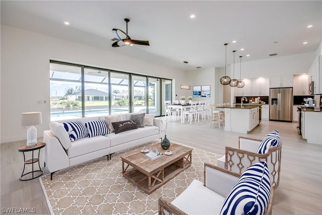 living room featuring light wood-type flooring and ceiling fan