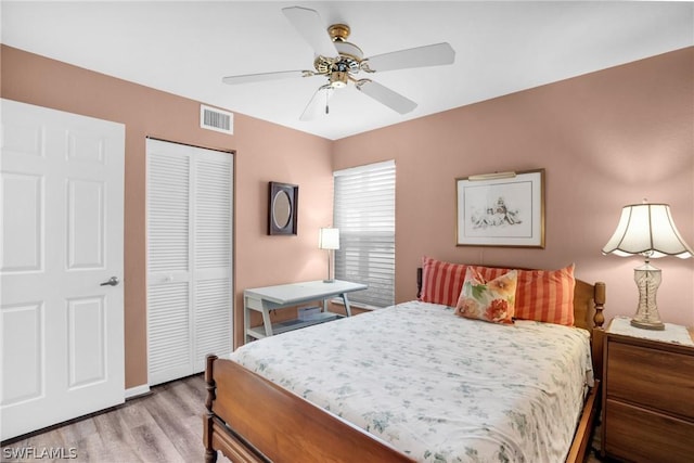 bedroom featuring ceiling fan, a closet, and hardwood / wood-style flooring