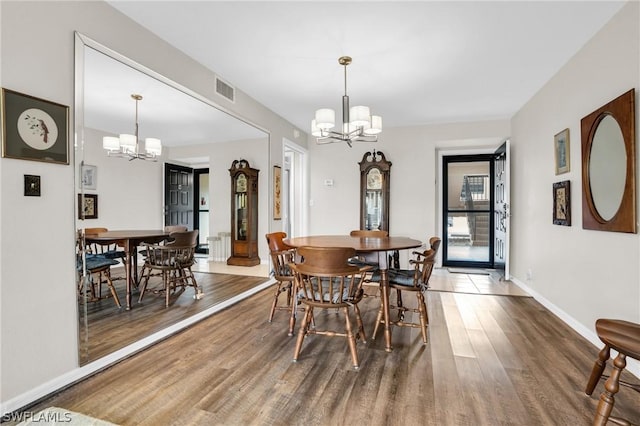 dining area with an inviting chandelier and hardwood / wood-style flooring