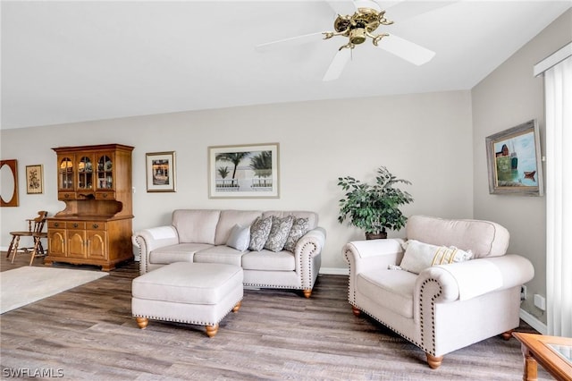 living room featuring ceiling fan and dark wood-type flooring