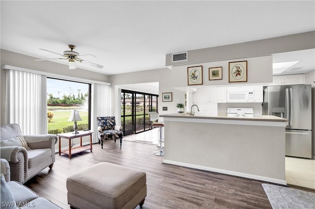 living room with hardwood / wood-style flooring, ceiling fan, and sink