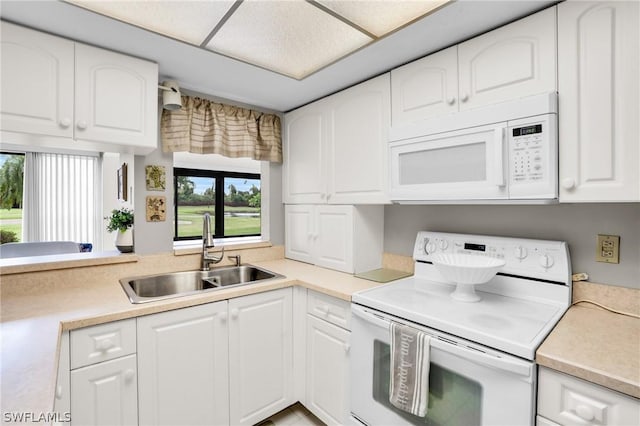 kitchen featuring sink, white appliances, and white cabinets