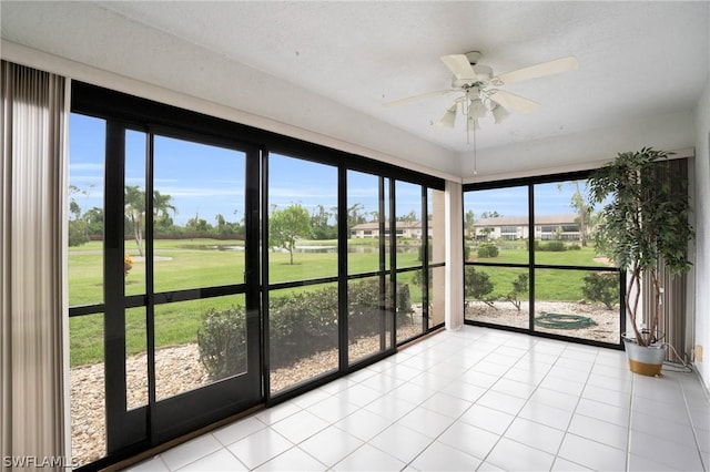 unfurnished sunroom featuring ceiling fan and plenty of natural light