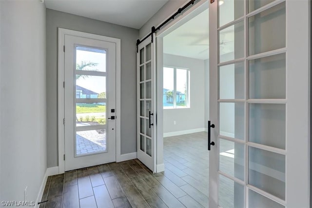 doorway to outside featuring wood-type flooring, a barn door, and french doors