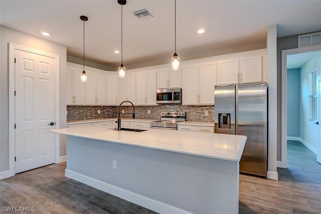 kitchen featuring stainless steel appliances, white cabinetry, and sink