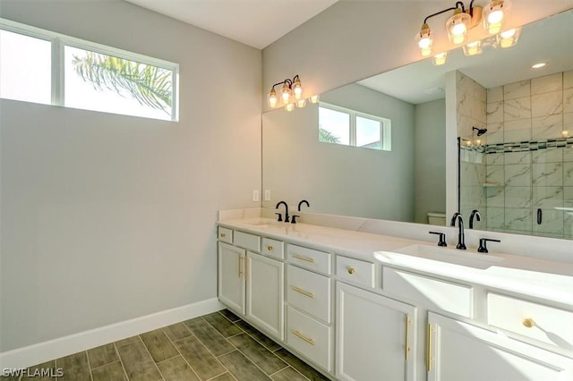 bathroom featuring vanity, toilet, and a shower with shower door