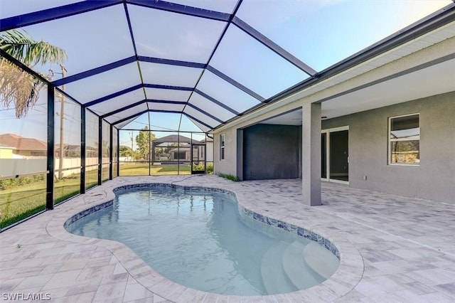 view of pool with glass enclosure and a patio area