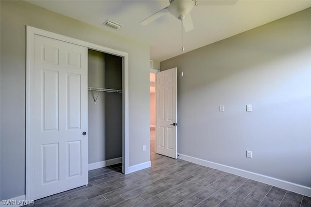 unfurnished bedroom with dark hardwood / wood-style flooring, a closet, and ceiling fan