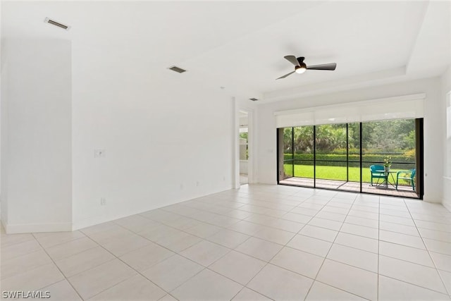 empty room with light tile patterned flooring, a ceiling fan, and visible vents