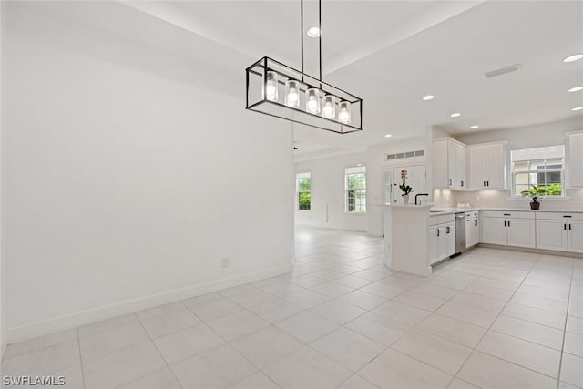 kitchen featuring white cabinetry, light countertops, open floor plan, dishwasher, and tasteful backsplash