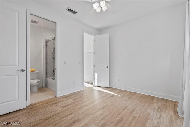 unfurnished bedroom featuring visible vents, baseboards, connected bathroom, and light wood finished floors