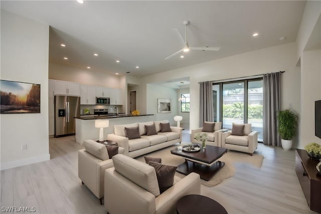 living room with ceiling fan, sink, and light hardwood / wood-style flooring