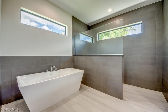 bathroom with tile walls and a bathing tub