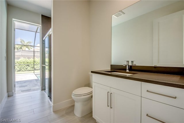 bathroom featuring vanity, toilet, and an enclosed shower