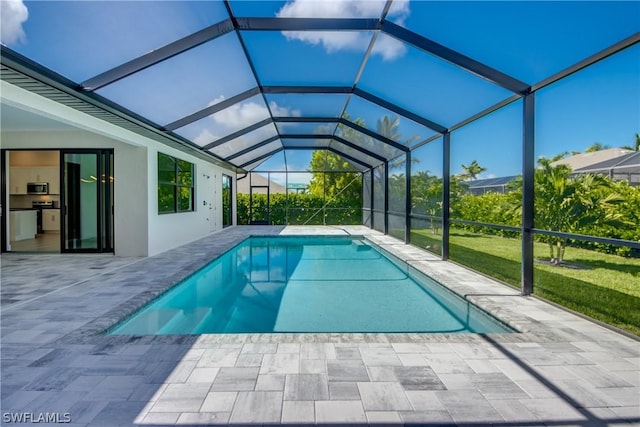 view of pool with a patio and glass enclosure