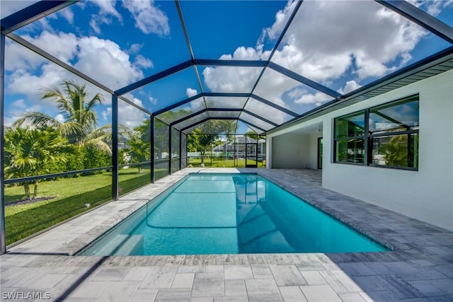 view of swimming pool featuring glass enclosure, a yard, and a patio area