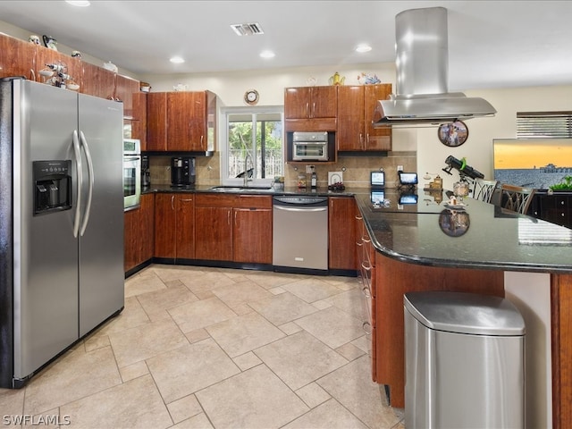 kitchen with island range hood, sink, tasteful backsplash, appliances with stainless steel finishes, and dark stone countertops