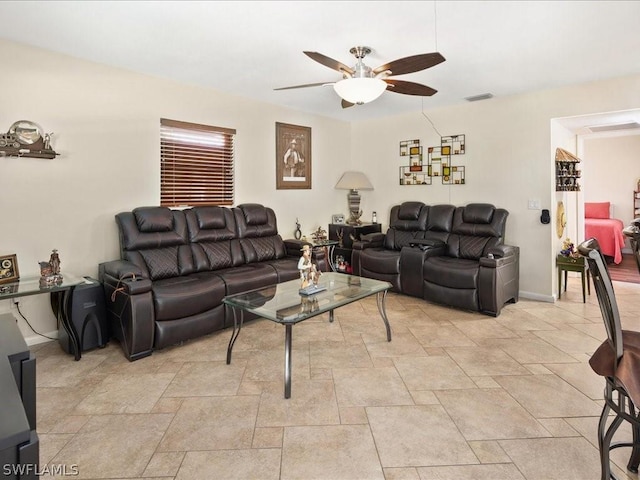 living area with ceiling fan, stone finish floor, visible vents, and baseboards