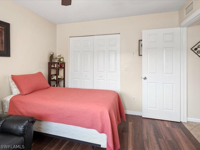 bedroom featuring a closet, visible vents, baseboards, and wood finished floors