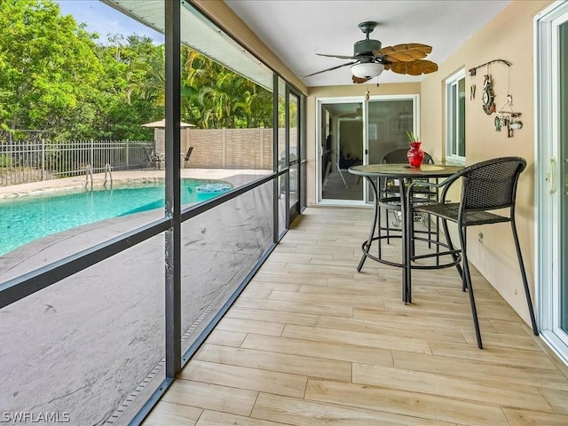 unfurnished sunroom with ceiling fan