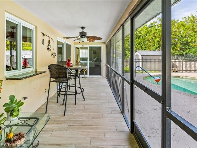 sunroom / solarium with ceiling fan and a healthy amount of sunlight