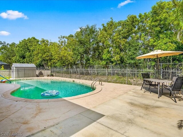 view of swimming pool featuring an outbuilding and a patio area