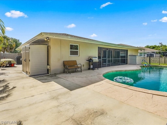 back of house featuring central AC, fence, a sunroom, stucco siding, and a patio area