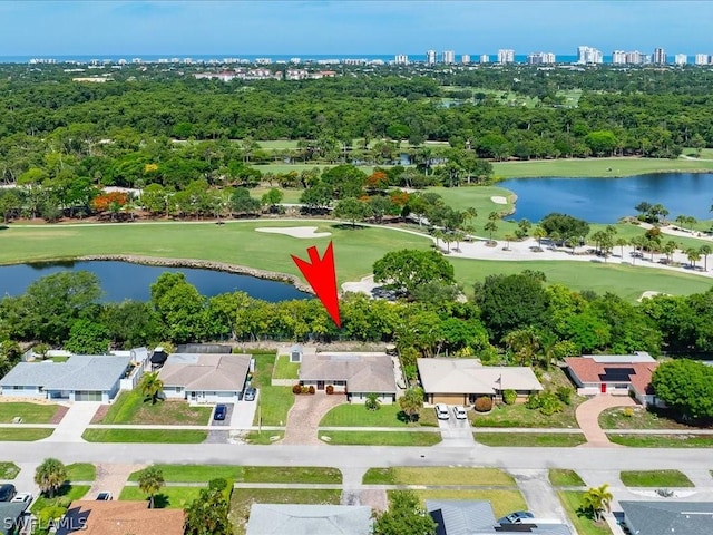 drone / aerial view with view of golf course and a water view