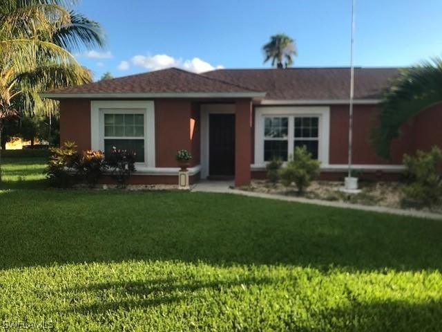 ranch-style house with a front lawn and stucco siding