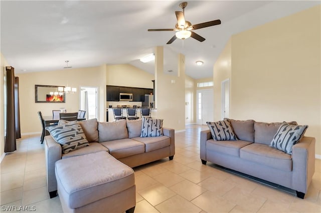 living room with ceiling fan with notable chandelier, plenty of natural light, light tile patterned floors, and lofted ceiling