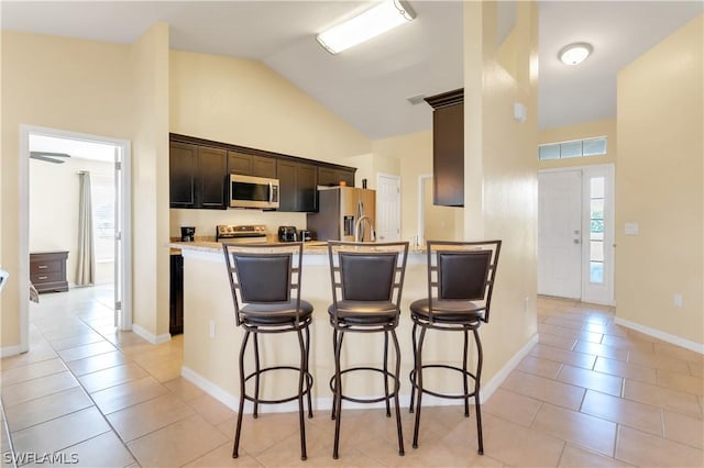 kitchen with a wealth of natural light, light tile patterned floors, and appliances with stainless steel finishes