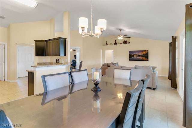 tiled dining room with ceiling fan with notable chandelier and lofted ceiling