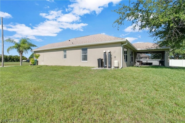 rear view of house featuring a lawn