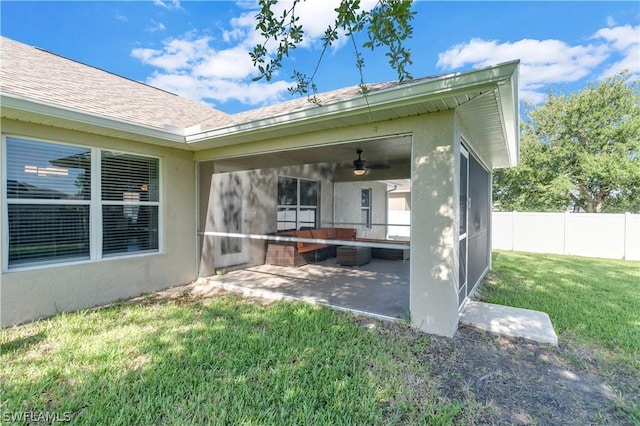 rear view of property featuring a lawn, ceiling fan, and a patio