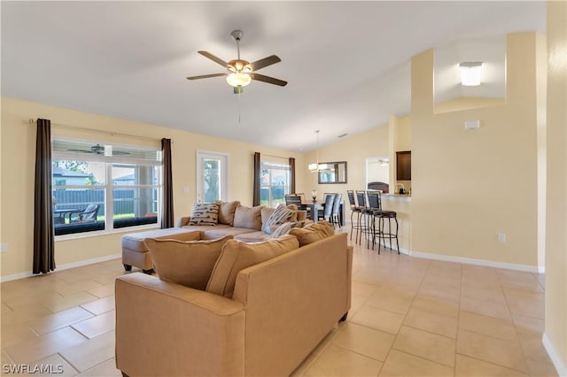 tiled living room with lofted ceiling, ceiling fan, and a healthy amount of sunlight