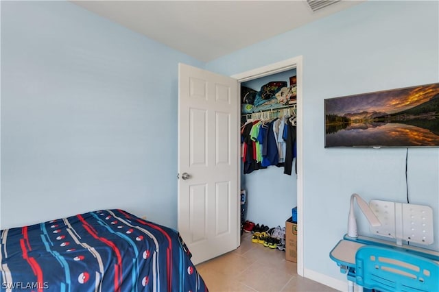 bedroom with a closet and light tile patterned floors