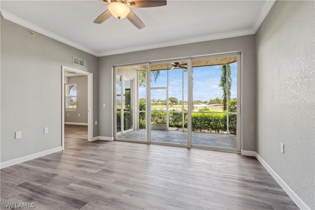 empty room with ceiling fan, wood-type flooring, and ornamental molding