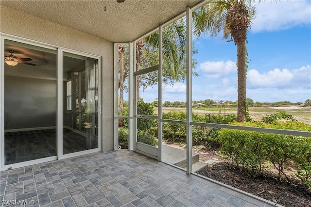 unfurnished sunroom with ceiling fan