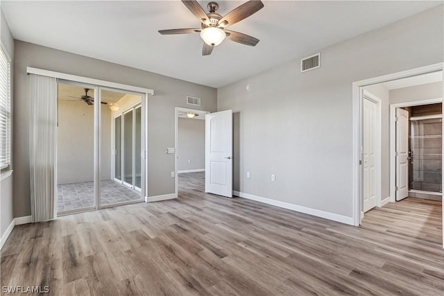 unfurnished bedroom featuring ceiling fan, a closet, and light hardwood / wood-style flooring