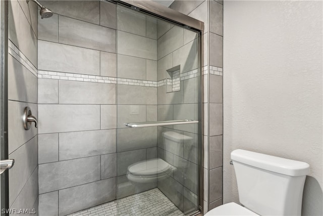 bathroom with toilet and an enclosed shower