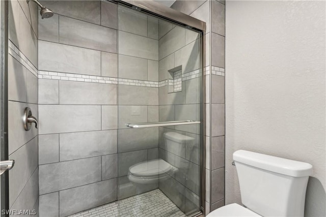 bathroom featuring toilet and an enclosed shower