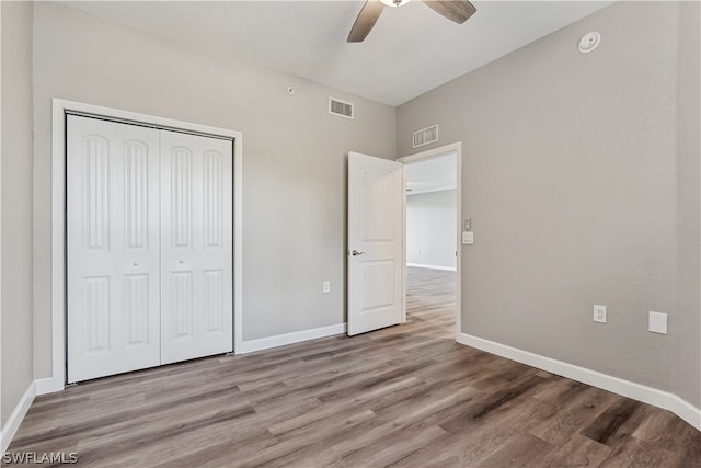 unfurnished bedroom with hardwood / wood-style flooring, a closet, and ceiling fan