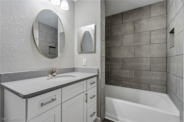 bathroom featuring vanity and tiled shower / bath