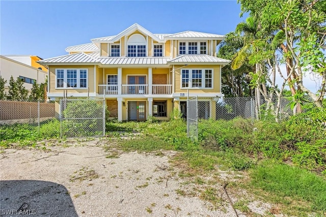 view of front of home featuring metal roof, a standing seam roof, and fence