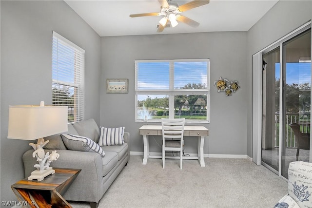 carpeted office featuring baseboards and ceiling fan
