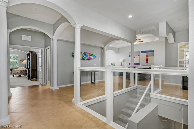 interior space with plenty of natural light, tile patterned floors, visible vents, and ornate columns