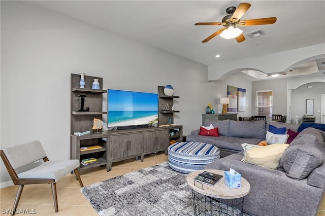 tiled living area with visible vents, a ceiling fan, and arched walkways