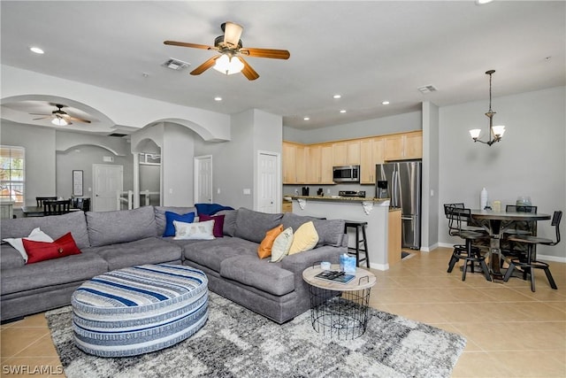 living room with visible vents, light tile patterned floors, ceiling fan with notable chandelier, recessed lighting, and arched walkways