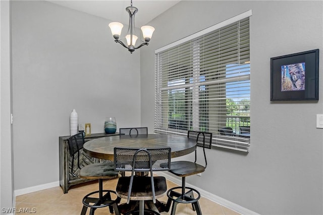 dining space featuring light tile patterned floors, a notable chandelier, and baseboards