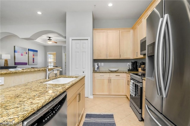 kitchen featuring light brown cabinets, ceiling fan, light tile patterned floors, appliances with stainless steel finishes, and a sink